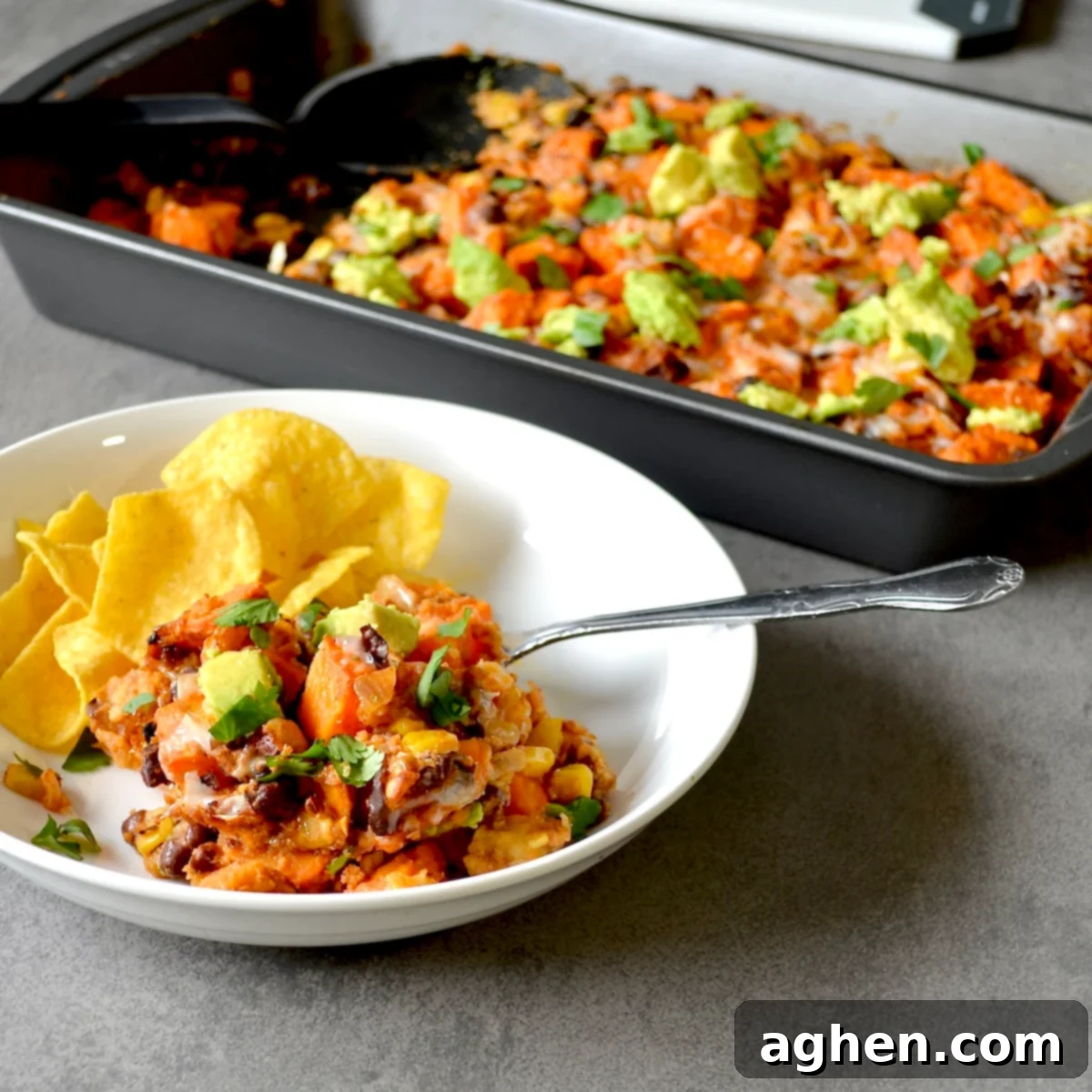 Weight Watchers Sweet Potato Black Bean Enchilada Casserole served with tortilla chips and a dollop of sour cream.