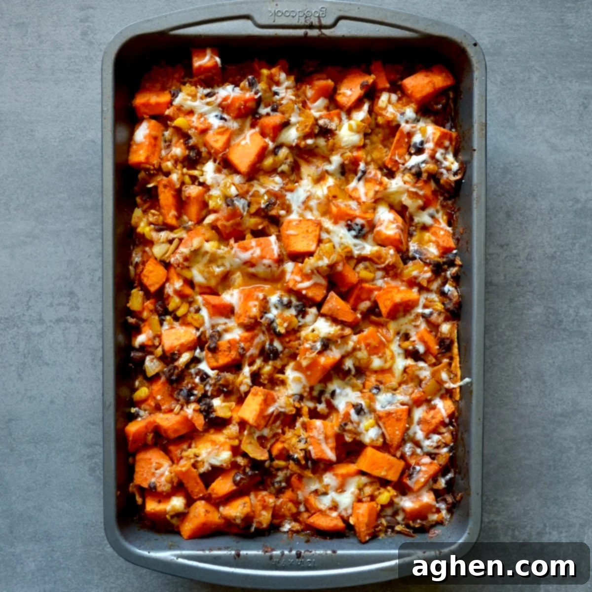 Baked sweet potato black bean enchilada casserole fresh out of the oven, topped with melted cheese.