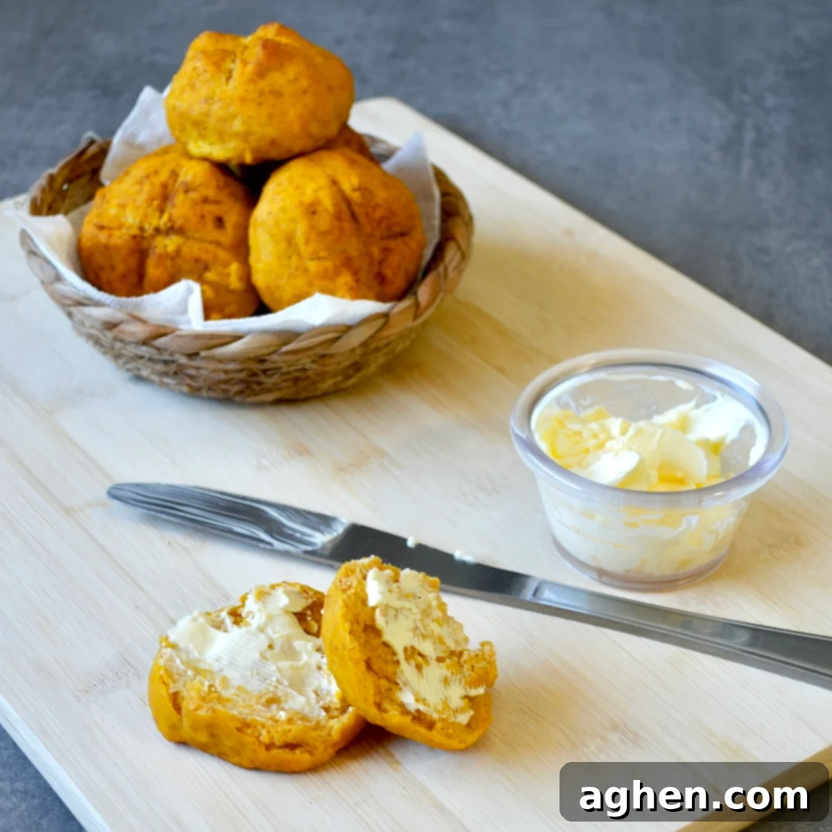 Freshly baked pumpkin dinner rolls brushed with butter, ready to serve