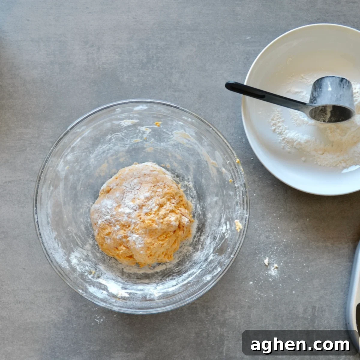 Smooth and pliable pumpkin dinner roll dough resting in a mixing bowl