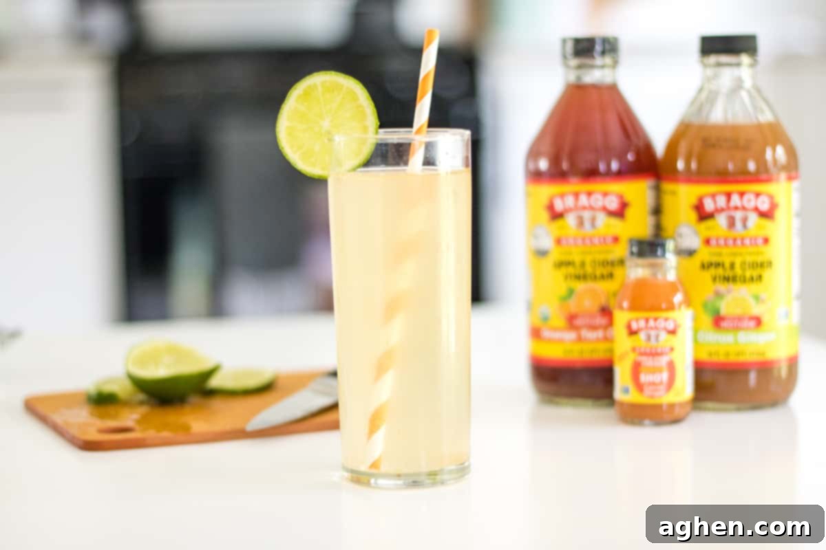 Zesty Apple Cider Tonic 3 Sparkling apple cider vinegar drink garnished with fresh lime. Bragg Apple Cider Vinegar and lime on cutting board in background.
