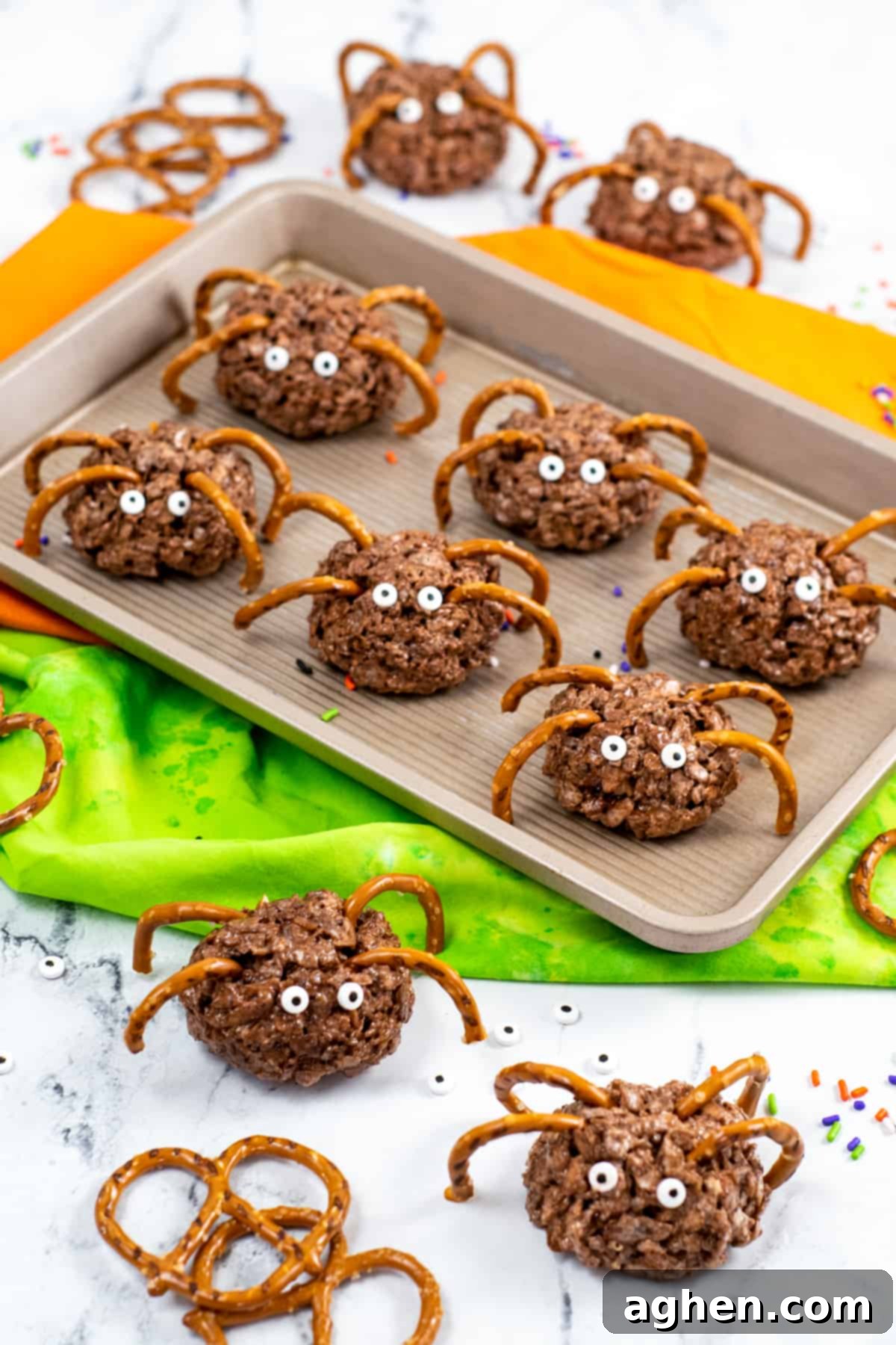 Frightfully Delicious Spider Bites 2 Spider-shaped rice cereal treats with pretzels as legs and edible candy eyes on a Halloween-themed background.