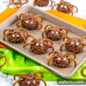 Frightfully Delicious Spider Bites 11 Chocolate rice krispies spider treats with pretzel legs and candy eyes on a black background, perfect for a Halloween party.