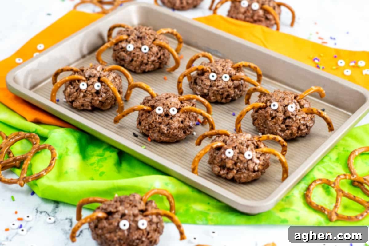 Frightfully Delicious Spider Bites 10 Chocolate rice krispies spider treats with pretzel legs and candy eyes, presented on a dark plate.