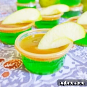 Green apple jello shot with caramel vodka, caramel topping, and fresh apple wedge.