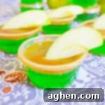Green apple jello shot with caramel vodka, caramel topping, and fresh apple wedge.