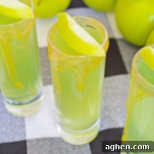 Decadent Caramel Apple Shots 5 Caramel Apple Shots with Caramel Vodka, caramel sauce on rim, and slice of apple as garnish