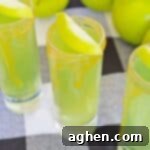 Decadent Caramel Apple Shots 6 Caramel Apple Shots with Caramel Vodka, caramel sauce on rim, and slice of apple as garnish