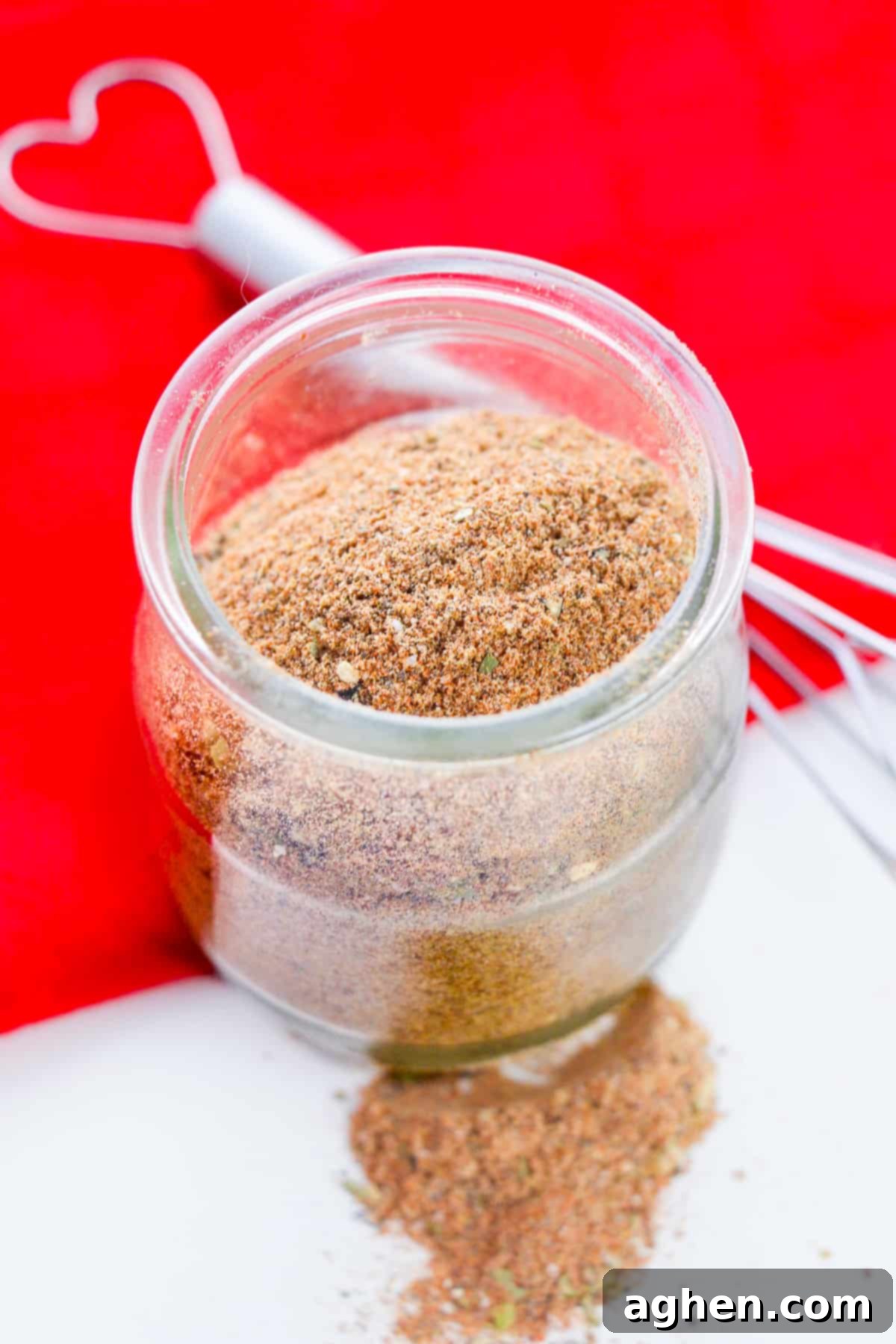Homemade Chili Seasoning Mix in small glass jar with wire whisk next to it