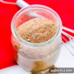 Homemade Chili Seasoning Mix in small glass jar with wire whisk next to it