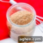 Homemade Chili Seasoning Mix in small glass jar with wire whisk next to it