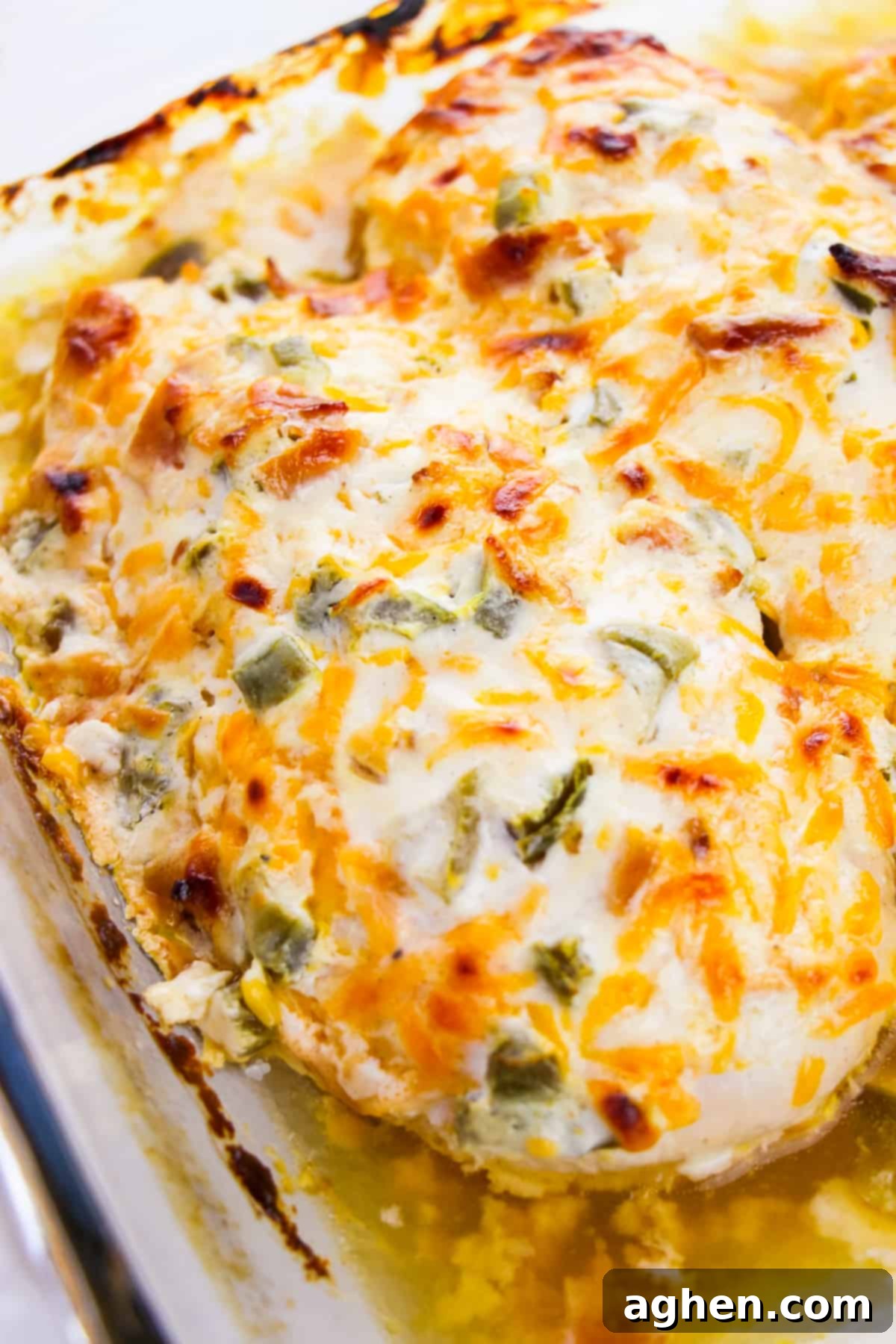 Baked jalapeño popper chicken breast in a casserole dish, fresh out of the oven with a golden brown top.