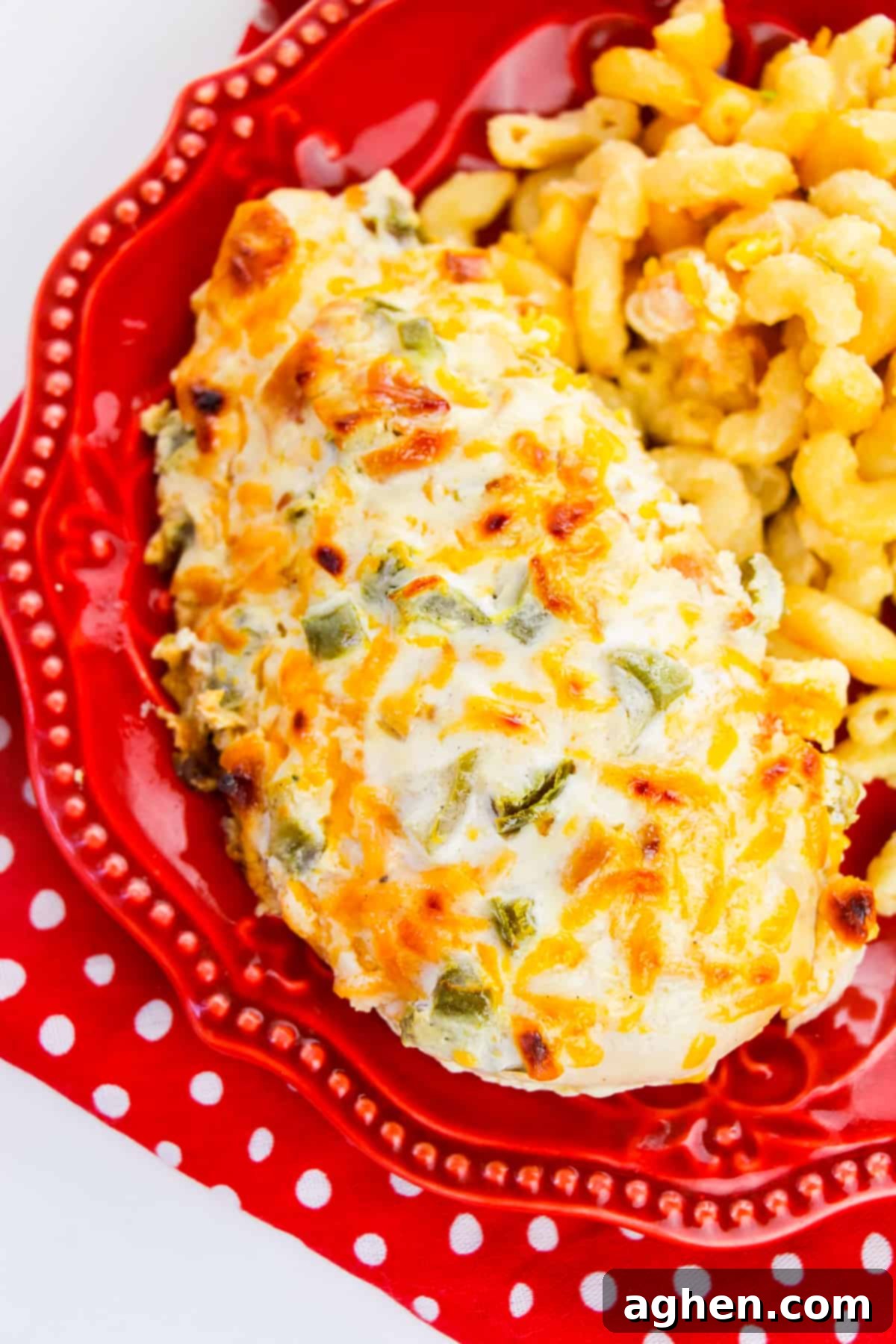 Chicken breast topped with creamy jalapeño mixture served alongside macaroni and cheese, showcasing the deliciousness of the easy dish.