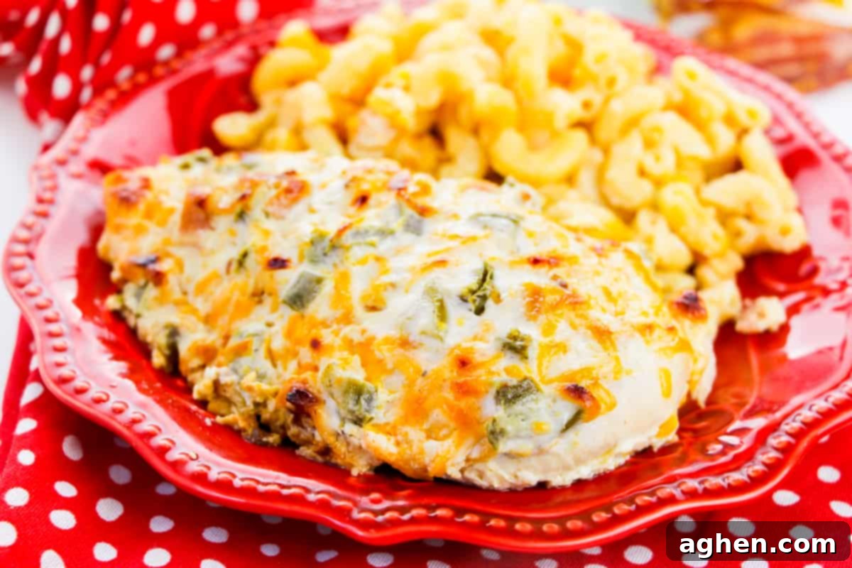 A single serving of jalapeño popper chicken breast on a red plate, with macaroni and cheese on the side, ready to be enjoyed.