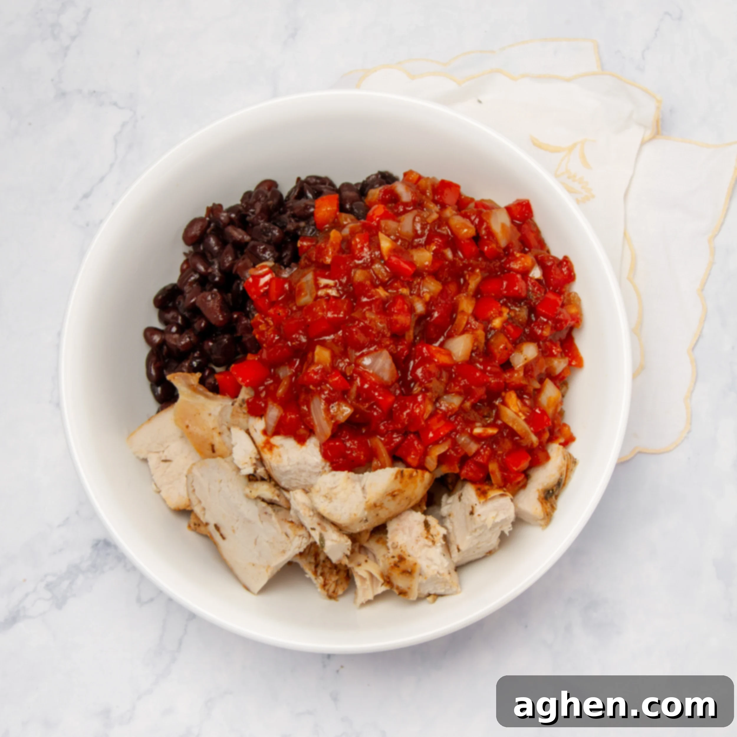 Your Go-To Weight Watchers Mexican Chicken Casserole 6 A large bowl filled with cubed chicken, sautéed vegetables, and black beans, seasoned and ready for casserole assembly.