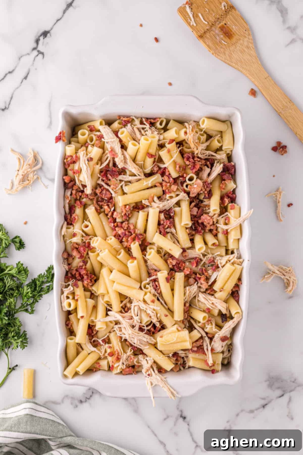 Casserole dish with ziti, crumbled bacon, shredded cooked chicken