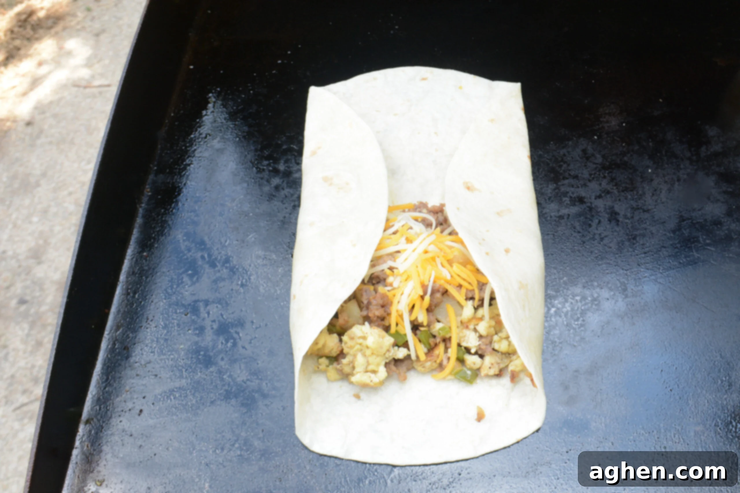 A close up of a burrito with the side sfolded in. 