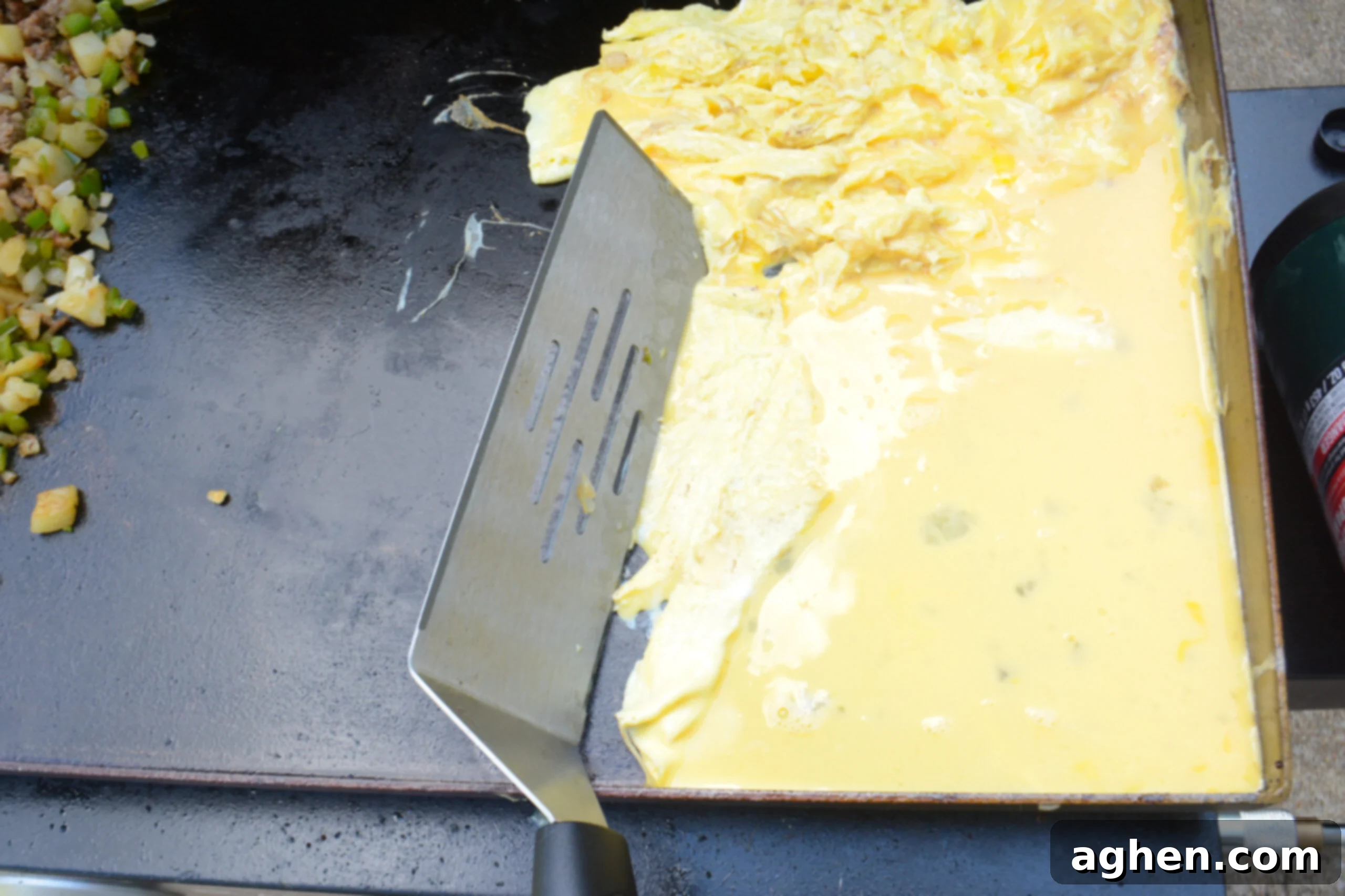 The spatula gently folds liquid eggs on the Blackstone. 