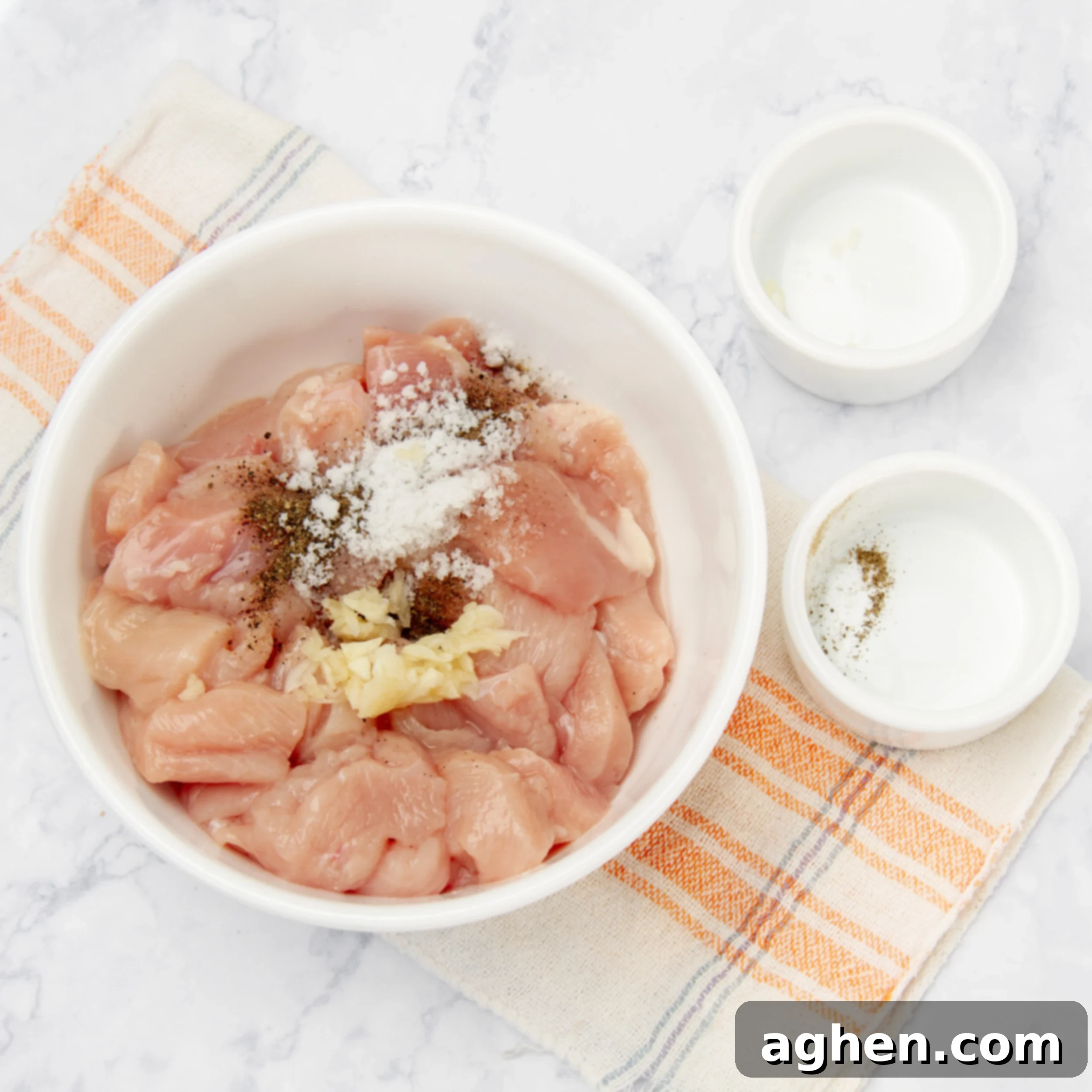 Diced chicken with seasonings in a small bowl.