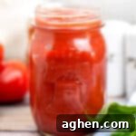 Close-up of homemade pizza sauce in a small mason jar.