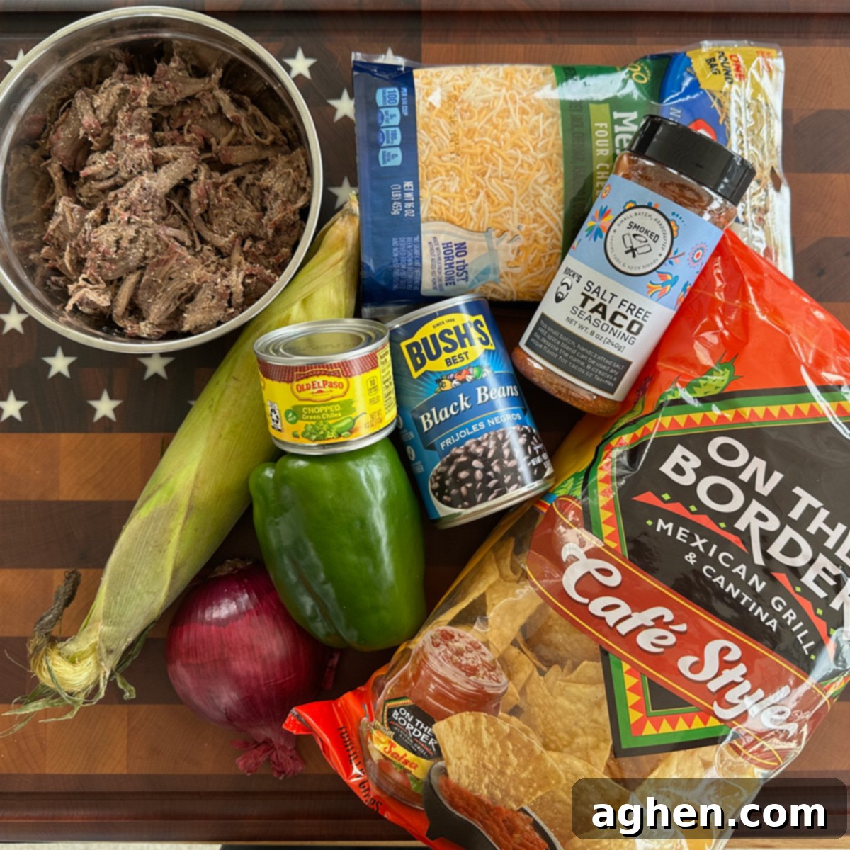 A selection of fresh ingredients laid out, including green peppers, onions, corn, black beans, and a bag of tortilla chips, ready for making Traeger Cast Iron Nachos.