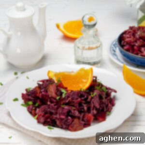Slow Cooker Tangy Red Cabbage 7 Crunchy slow cooker tangy red cabbage on a serving plate with an orange wedge on top.