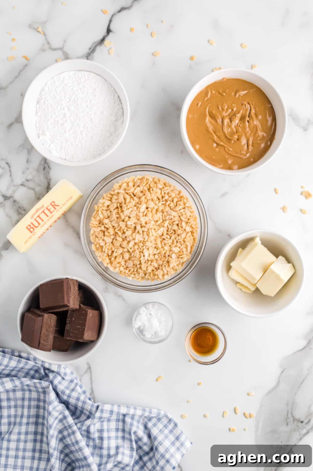 No-Bake Peanut Butter Crunch Bites 4 Ingredients in bowls on countertop: powdered sugar, creamy peanut butter, vegetable shortening, vanilla extract, crispy rice cereal, chocolate and vanilla almond bark, and a stick of butter.