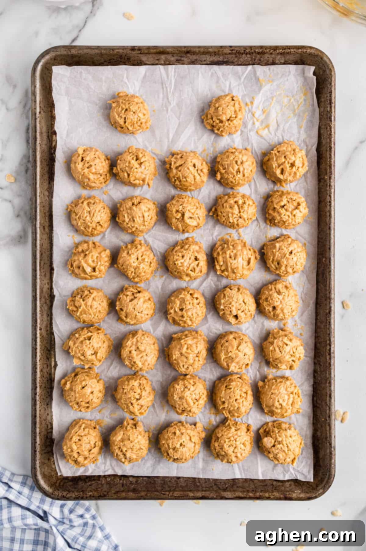 No-Bake Peanut Butter Crunch Bites 6 Rice Krispie Peanut Butter Balls on a lined baking sheet, chilled and ready for chocolate coating.