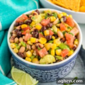 Cowboy Caviar dip with beans, avocado, corn, scallions, and dressing in a bowl, served with tortilla chips