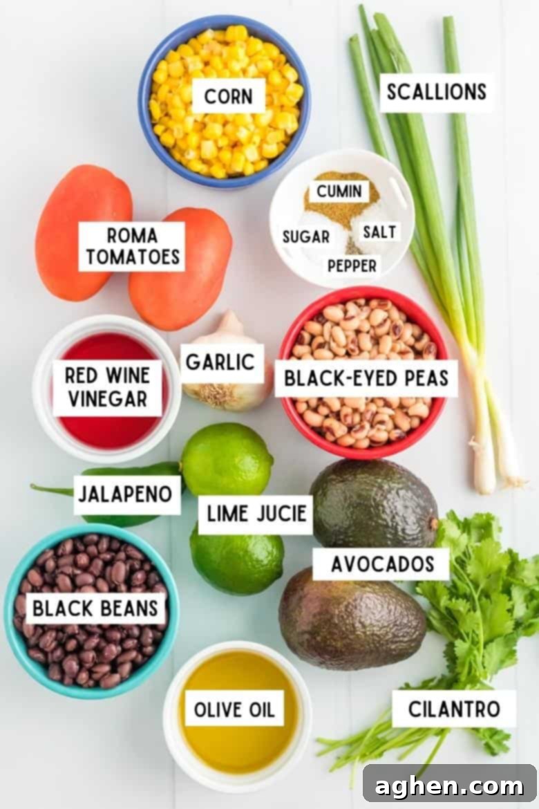 Ingredients for Cowboy Caviar laid out on a countertop: canned corn kernels, fresh scallions, Roma tomatoes, red wine vinegar, black-eyed peas, black beans, olive oil, ripe avocados, limes, fresh cilantro, garlic cloves, salt, pepper, sugar, and ground cumin.