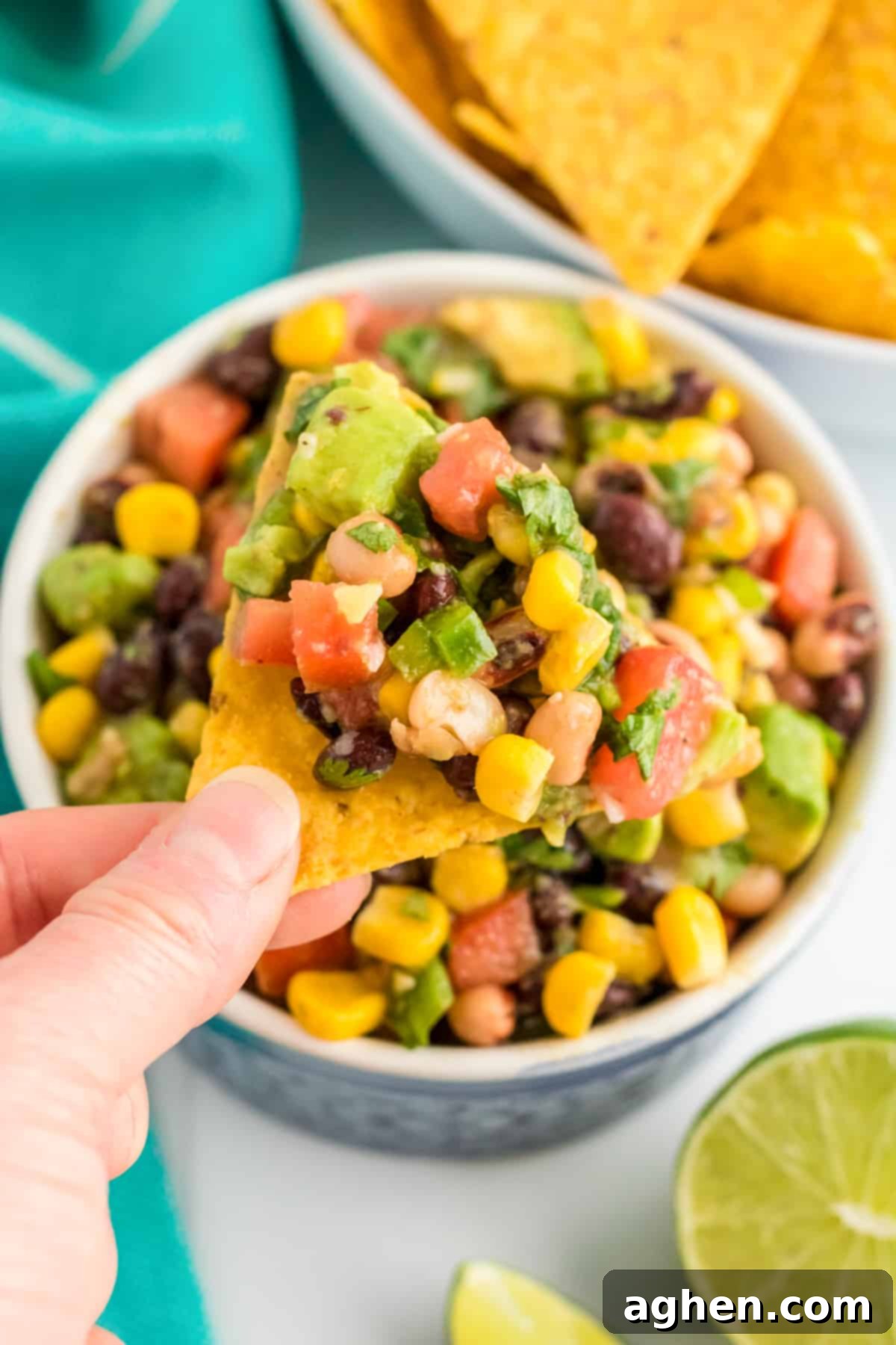Cowboy Caviar Dip scooped onto a tortilla chip, ready to be eaten.