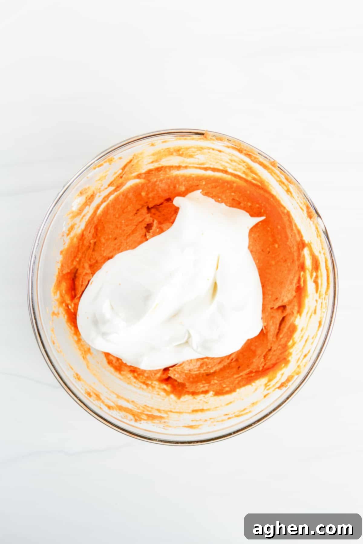 In process image of Cool Whip being added to pumpkin dip