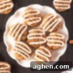 Carrot cake cookies with cream cheese frosting piped on top in zig zag pattern.
