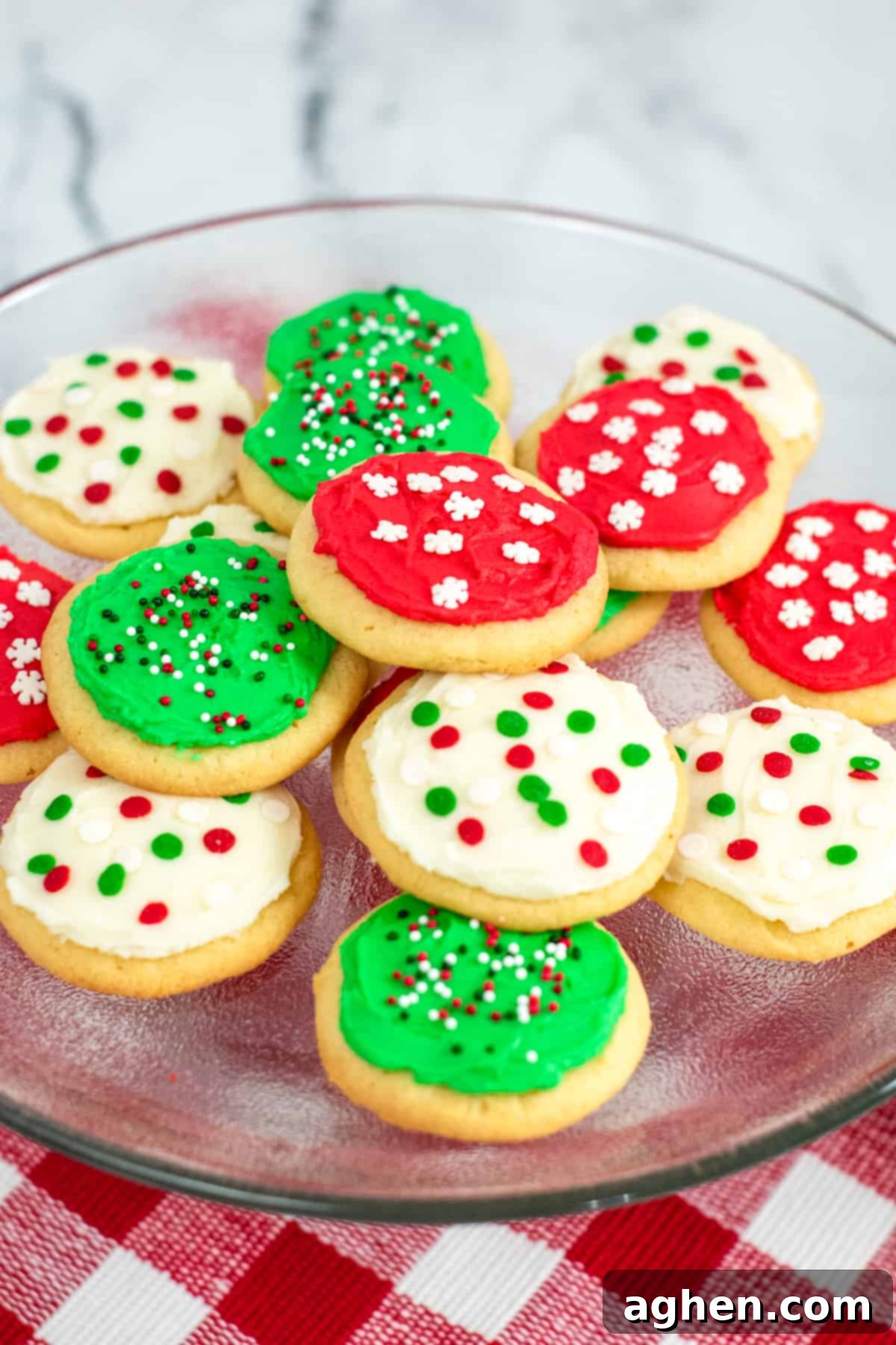 Tender Holiday Frosted Cookies 2 Platter of round frosted sugar cookies decorated with red, green, and white frosting and christmas sprinkles