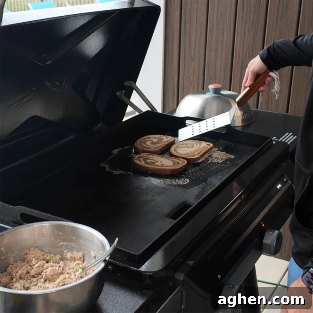 Rye bread slices crisping on a griddle, with one side already flipped.