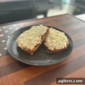 Finished Open-faced Tuna Melt on Rye, served hot with melted cheese.