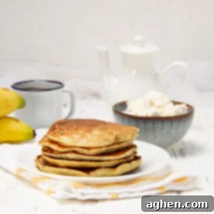 A stack of sweet and satisfying banana omelet on a plate with a bowl of cottage cheese on the side.