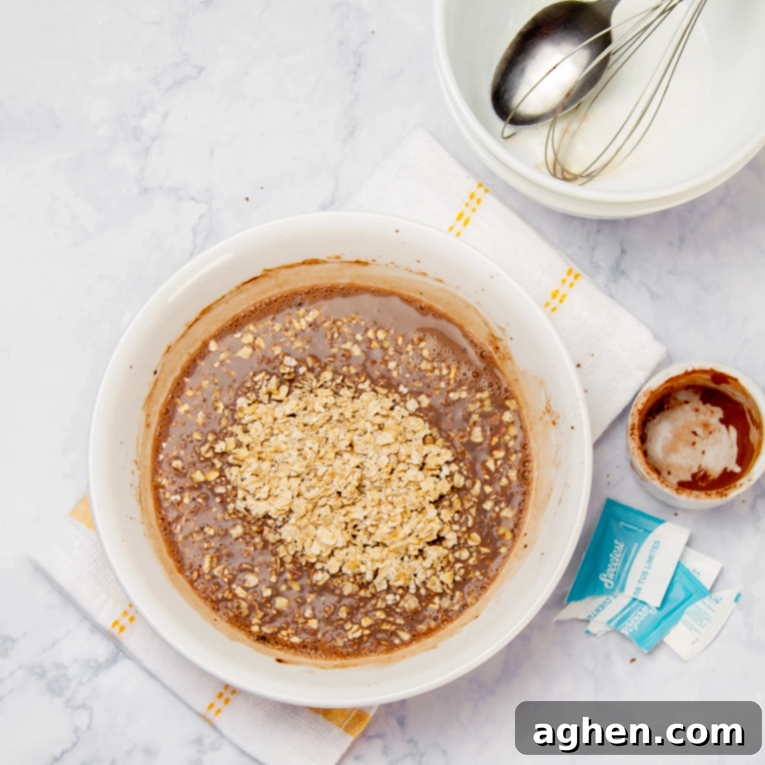 Chocolate Oat Bliss 5 Sweetener and oats added to the chocolate milk mixture in a small bowl.