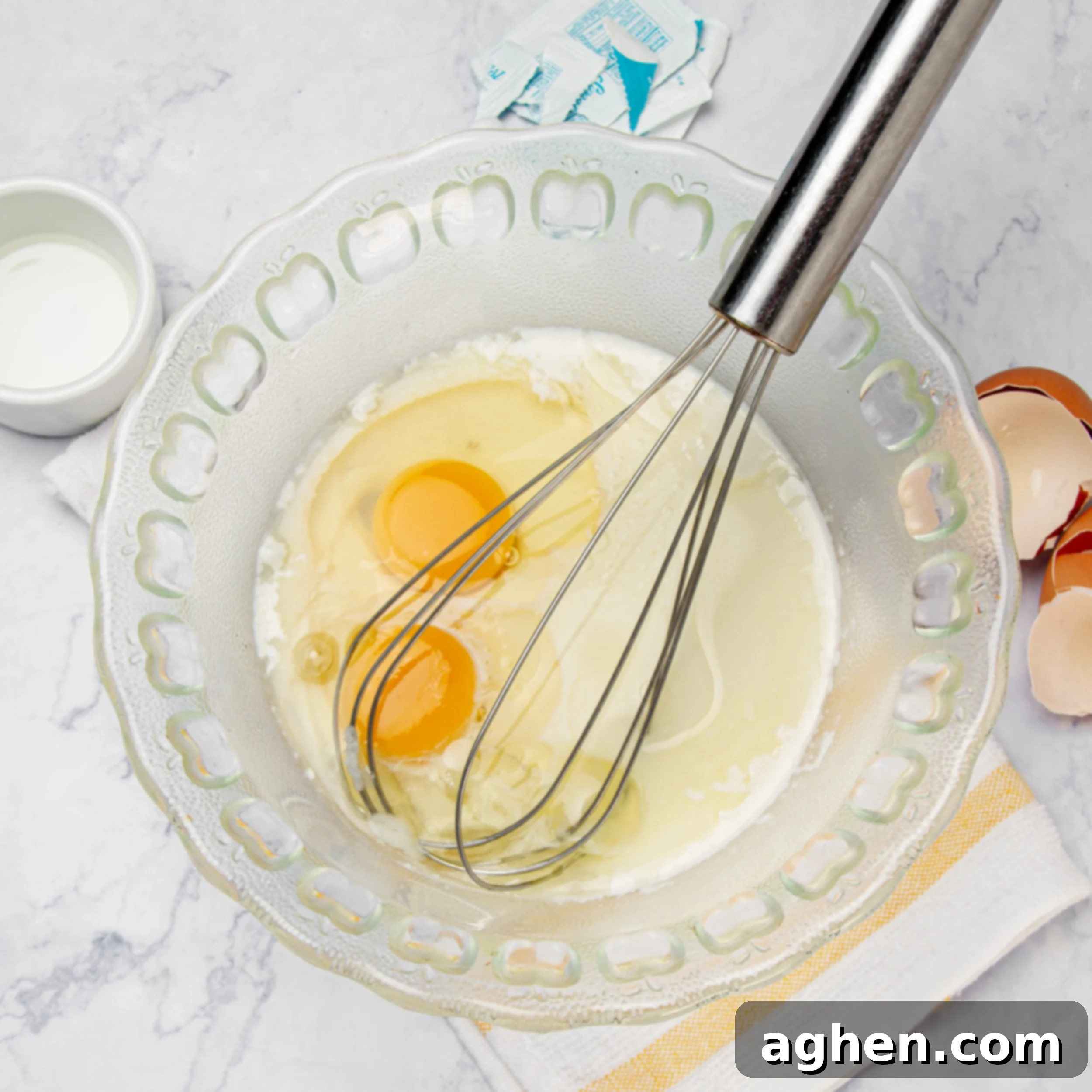 Golden Sweet Potato Pancakes 4 Eggs, milk, and oil being whisked together in a white bowl, illustrating the wet ingredients step.