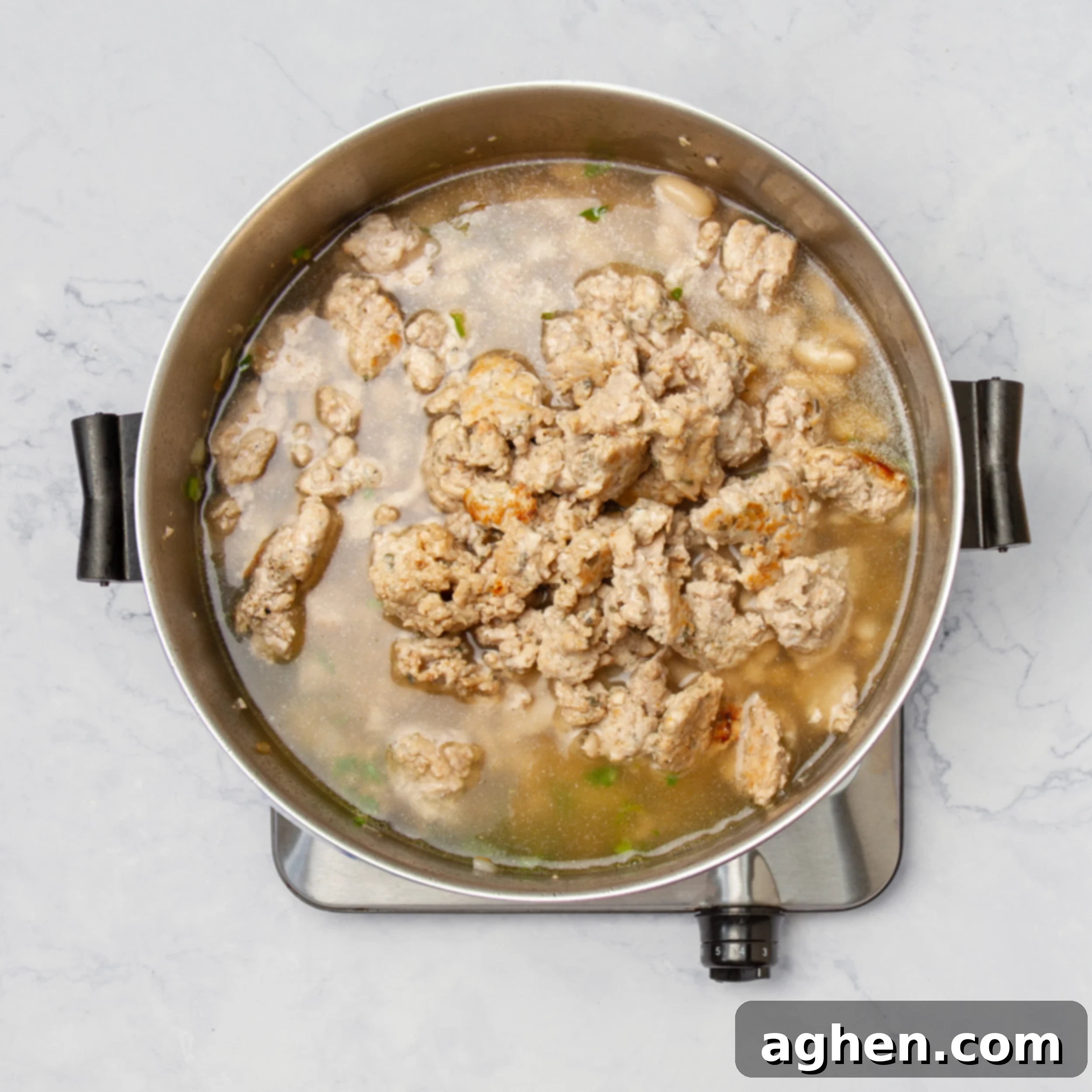 A close-up view of all the White Turkey Chili ingredients bubbling and simmering together in a pot, ready to be enjoyed.