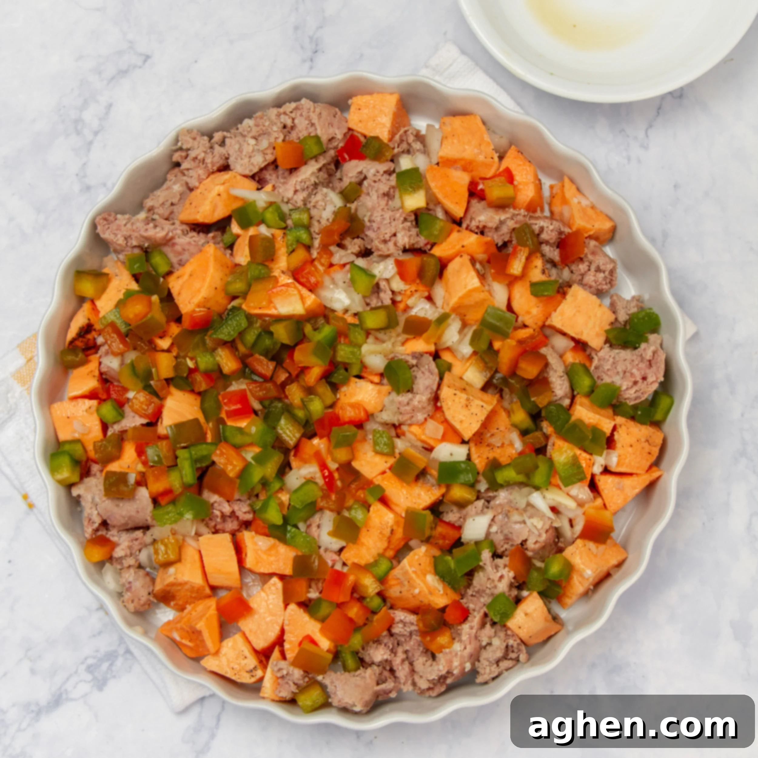 Sweet potatoes, sausage and veggies in a baking dish. 