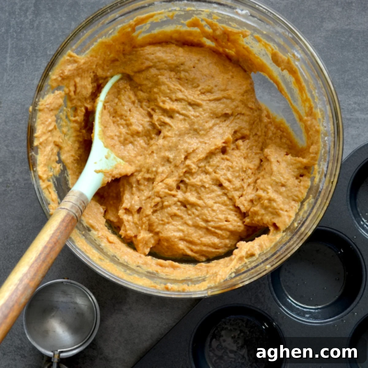 Thick pumpkin muffin batter in a mixing bowl, showing its ready-to-scoop consistency.