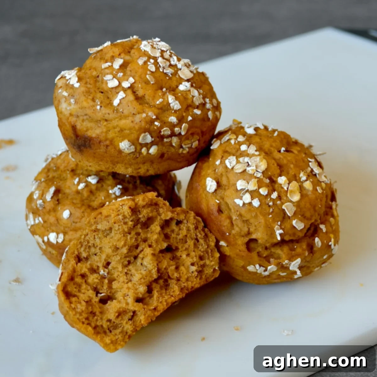 Freshly baked pumpkin muffins adorned with oats, cooling on a rack, ready for a healthy snack.