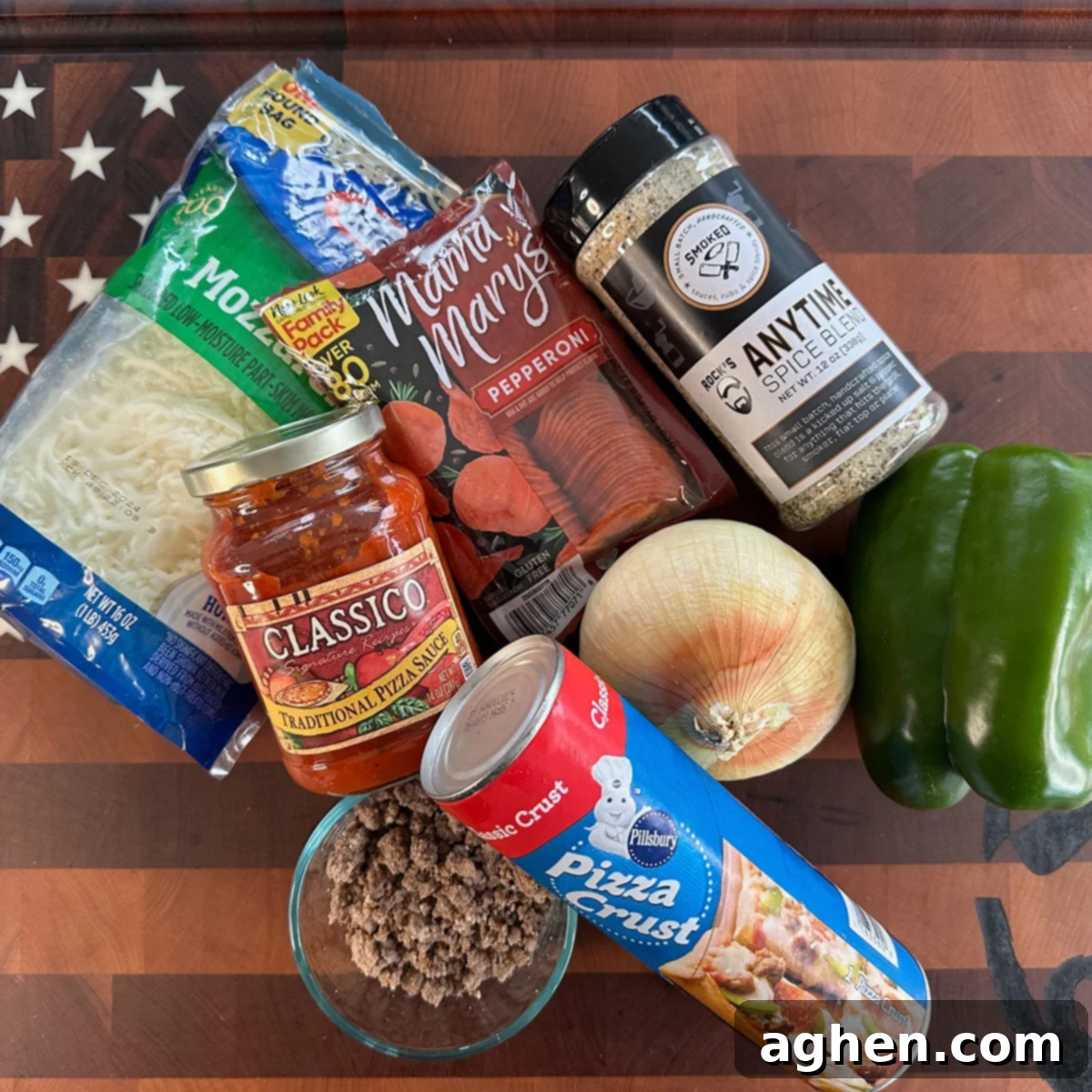 Griddle Pizza: My New Culinary Addiction 3 A selection of fresh pizza ingredients laid out on a cutting board, including cheese, pepperoni, ground beef, and onions.