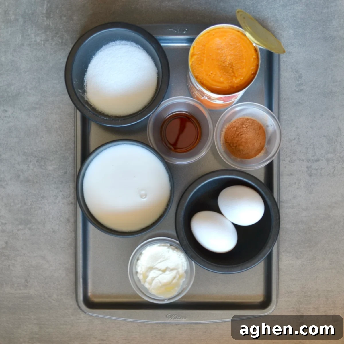 All the fresh ingredients for making a healthy crustless pumpkin pie laid out on a kitchen counter.