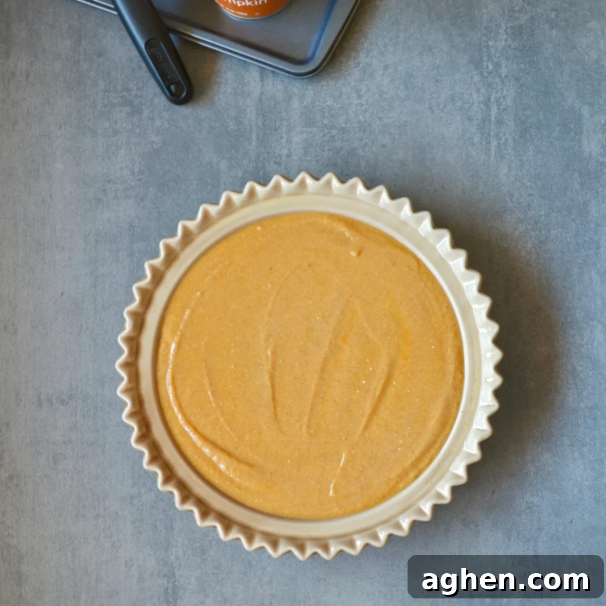 Crustless pumpkin pie mixture in a greased pie plate, ready for baking.