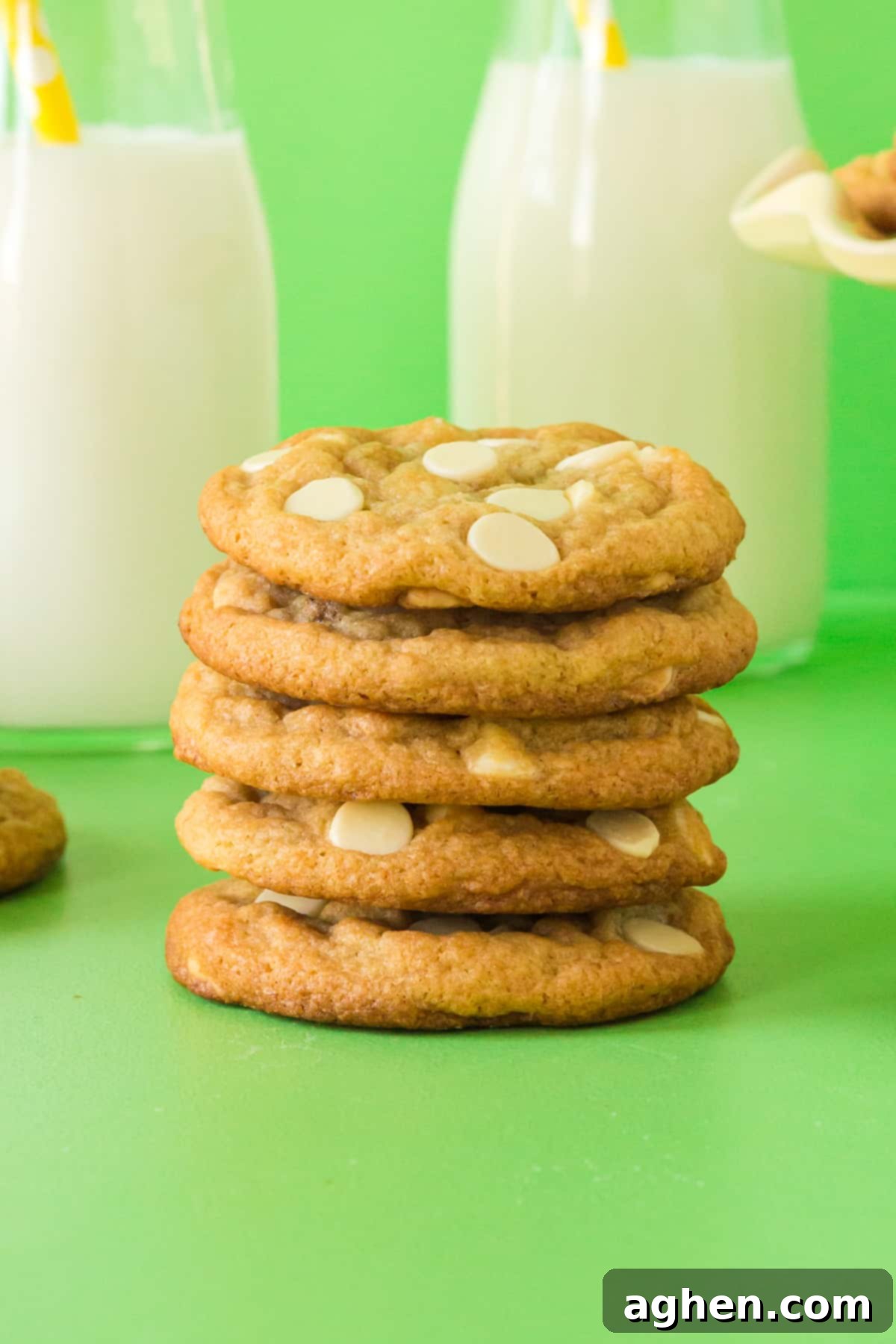 Chewy banana pudding cookies stacked on top of one another with milk in the background.
