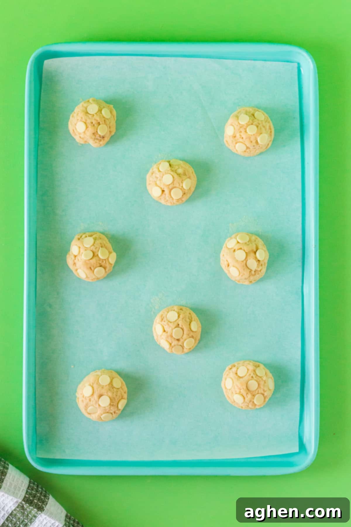 White chocolate chip banana cookies on lined baking sheet.