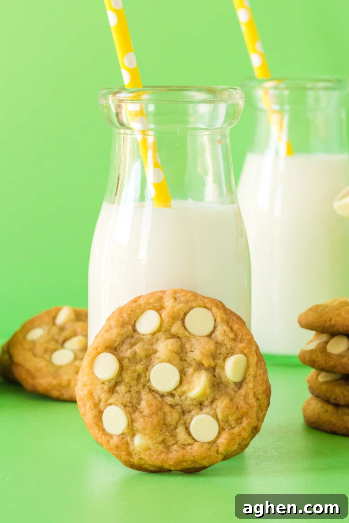 Banana Pudding Cookie with white chocolate chips leaning against a glass of milk.