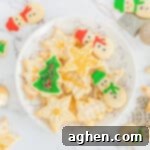 Decorated Christmas sugar cookies with icing and sprinkles on serving plate with additional cookies scattered around table